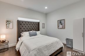 Dallas house for rent - A bedroom with a large bed and a wall-mounted air conditioner unit.