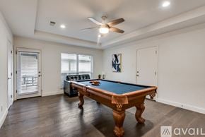 Dallas house for rent - A pool table in a room with a ceiling fan.