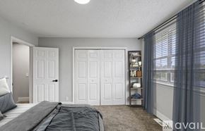 Nashville apartment for rent - A bedroom with a bed, two doors, and a window with curtains.