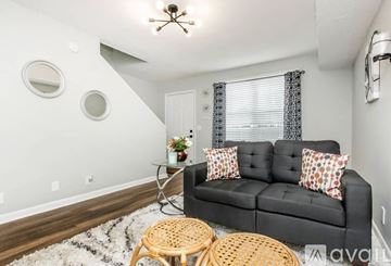 Nashville apartment for rent - A living room with a black couch and a round mirror on the wall.