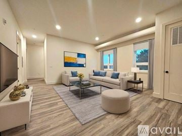 East Orange apartment for rent - A living room with a white couch, a coffee table, and a painting on the wall.