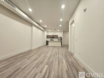 East Orange apartment for rent - A long, empty hallway with wood flooring and white walls.