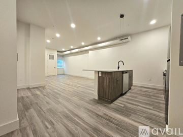 East Orange apartment for rent - A spacious kitchen with wooden flooring and a central island.