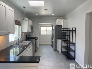 Los Angeles house for rent - A kitchen with black countertops and white cabinets.