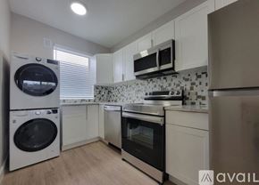 Miami apartment for rent - A kitchen with a washing machine and an oven.