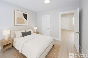 Miami apartment for rent - A bedroom with a large bed, a nightstand with a lamp, and a painting on the wall.