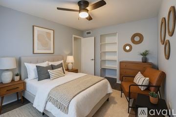 Dallas apartment for rent - A kitchen with white cabinets and a black fridge.