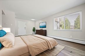 Lakewood apartment for rent - A bedroom with a large bed and a flat screen TV mounted on the wall.
