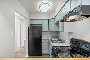 Lakewood apartment for rent - A kitchen with a black fridge and stove top oven.