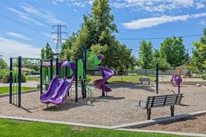 Lakewood apartment for rent - A playground with a purple slide and a green swing set.