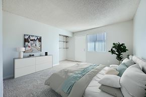 Tucson apartment for rent - A bedroom with a large bed and a painting on the wall.