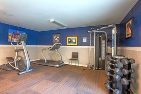 Tucson apartment for rent - A gym with a treadmill, exercise bike, and weights.