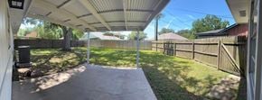 Bay City house for rent - A covered patio area with a concrete floor and a wooden fence.