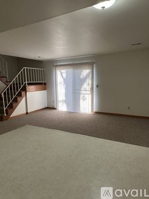 Pekin house for rent - A spacious room with a staircase and a sliding glass door.