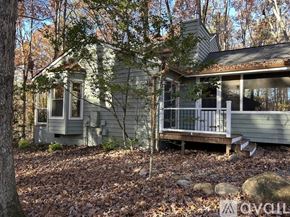 Chapel Hill house for rent - A small house with a porch is surrounded by trees.