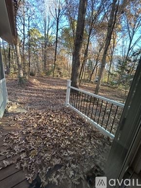Chapel Hill house for rent - A small house with a porch is surrounded by trees.