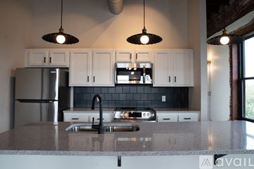 Toledo apartment for rent - A kitchen with a granite countertop and white cabinets.