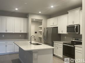 Lutz house for rent - A modern kitchen with white cabinets and stainless steel appliances.