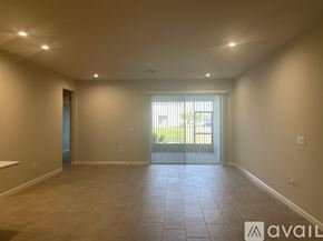 Lutz house for rent - A spacious room with tiled flooring and a sliding glass door leading to a balcony.
