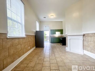 New Orleans house for rent - A kitchen area with a black refrigerator and white cabinets.