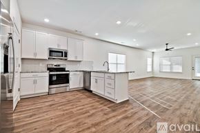 Mountain Home house for rent - A spacious kitchen with white cabinets and wooden flooring.