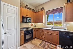 La Quinta house for rent - A kitchen with wooden cabinets and black appliances.