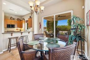 La Quinta house for rent - A dining room with a glass table and brown chairs.
