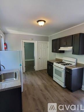 Newburgh apartment for rent - A kitchen with a white fridge, black cabinets, and a white stove.
