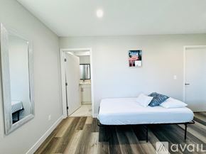 Los Angeles apartment for rent - A bedroom with a bed, a mirror, and a picture on the wall.