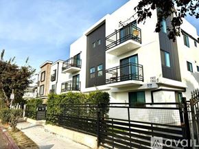 Los Angeles apartment for rent - A modern two-story building with balconies and a black gate.