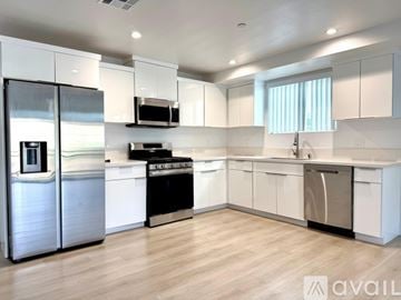 Los Angeles apartment for rent - A modern kitchen with white cabinets and stainless steel appliances.