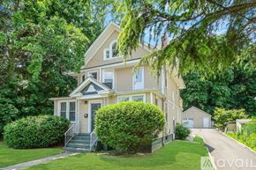 Huntington apartment for rent - A house with a front yard and a tree branch hanging over the front door.