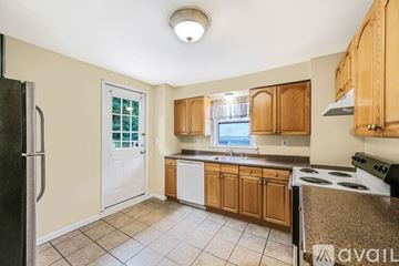 Huntington apartment for rent - A kitchen with wooden cabinets and a black refrigerator.