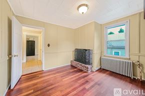 Huntington apartment for rent - A room with wooden floors and a brick fireplace.