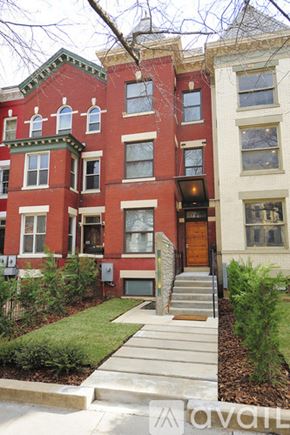 Washington townhouse for rent - A red brick building with a green lawn in front.