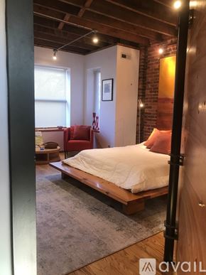 Washington townhouse for rent - A bedroom with a bed, chair, and a rug.