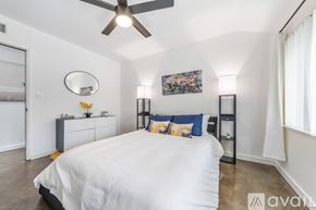 Los Angeles house for rent - A bedroom with a large bed and a ceiling fan.