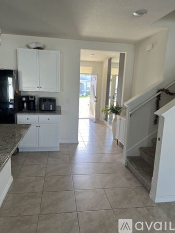 Davenport house for rent - A kitchen with white cabinets and a granite countertop.