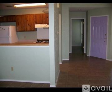 Austin townhouse for rent - A kitchen with wooden cabinets and a purple door.