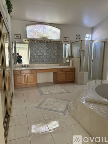 Las Vegas house for rent - A bathroom with a large mirror and a bathtub.