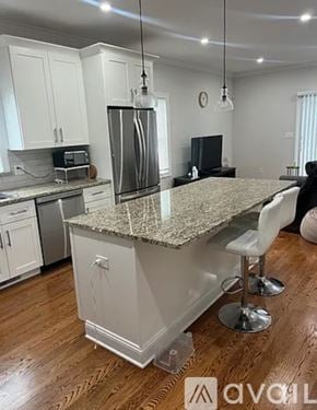 Harrison townhouse for rent - A kitchen with granite countertops and white cabinets.