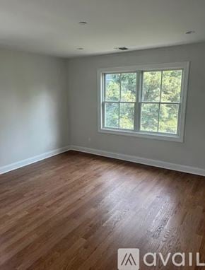 Harrison townhouse for rent - A room with wooden flooring and a window showing trees outside.