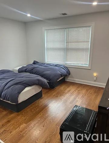 Harrison townhouse for rent - A bedroom with two beds and a wooden floor.