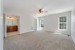 Jacksonville house for rent - A spacious room with a ceiling fan and carpeted floor.