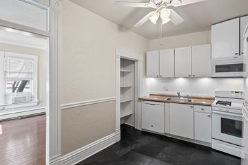 Denver apartment for rent - A kitchen with white cabinets and a black floor.