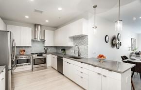 Denver house for rent - A modern kitchen with white cabinets and stainless steel appliances.