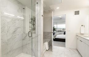 Denver house for rent - A bathroom with a walk-in shower and a bedroom in the background.