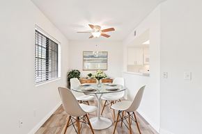Riverside apartment for rent - A dining room with a glass table and white chairs.