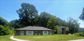 Woodville apartment for rent - A house with a grey roof is surrounded by greenery.