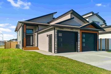 Grande Prairie apartment for rent - A modern house with a grey exterior and a black garage door.